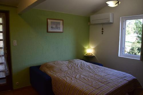 - une chambre avec un lit dans un mur vert dans l'établissement La Grangette, à Joyeuse