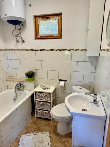 a bathroom with a toilet and a sink and a tub at Letnia Chata u Romana in Zalewo