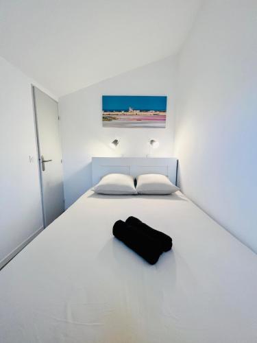 - une chambre dotée d'un lit blanc avec un sac noir dans l'établissement Villa cosy à Palavas-les-Flots, à Palavas-les-Flots