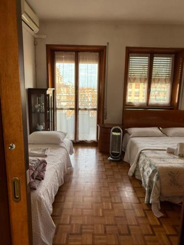 two beds in a room with two windows at #Punto FM 7# in Marghera