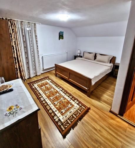 a bedroom with a bed and a rug at Casa Chindea Lacu Rosu in Lacu Rosu