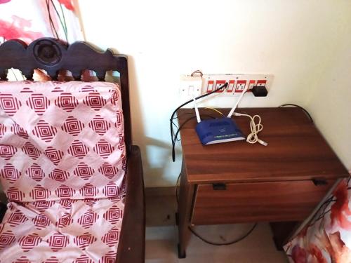 a bedroom with a bed and a wooden nightstand with a bed gmaxwell gmaxwell at Brewvilla 'Solaris ' in Puducherry