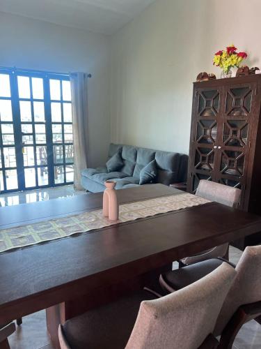 a dining room table with chairs and a couch at Cabaña Na-tatik in Ocosingo
