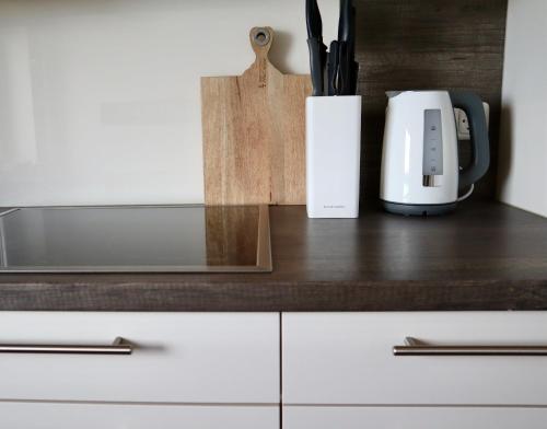 a counter top with a coffee maker and a cup at Ferienwohnung Strandhafer in Wittdün