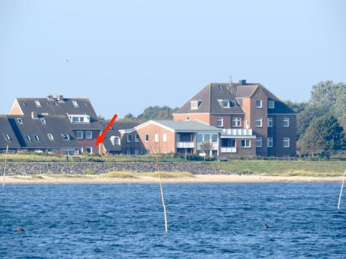 two boats in the water with houses in the background at Ferienwohnung Strandhafer in Wittdün