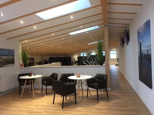 a restaurant with two tables and chairs in a room at Ferienwohnung Strandhafer in Wittdün