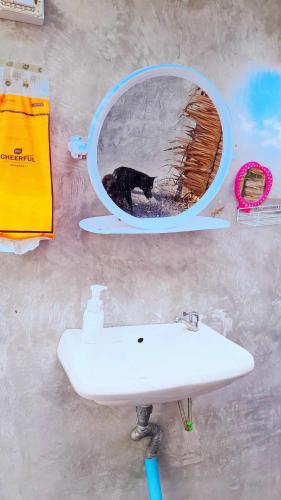 a bathroom sink and a mirror with a dog in it at Bamboo Village in Ban Tai