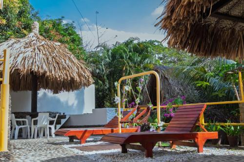 a group of chairs and a table and umbrella at Hotel Manakin Tayrona in El Zaino