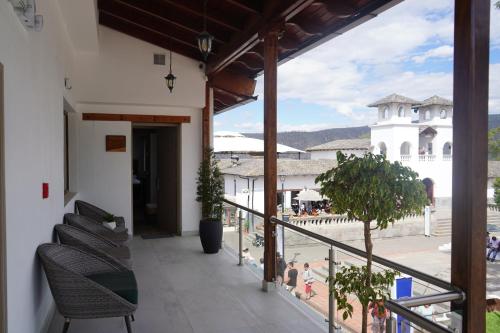a balcony with chairs and a view of a building at Hotel Boutique Mitad Del Mundo in Quito