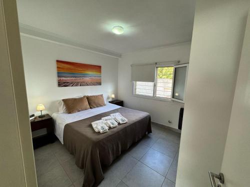a bedroom with a bed with two towels on it at Serranias de Tandil in Tandil