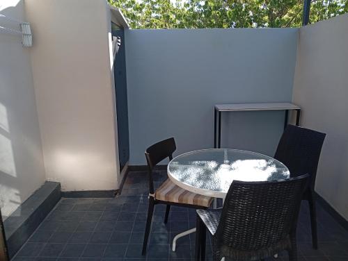 un patio con mesa de cristal y sillas en Estilo urbano. Moderno y confortable, en Neuquén