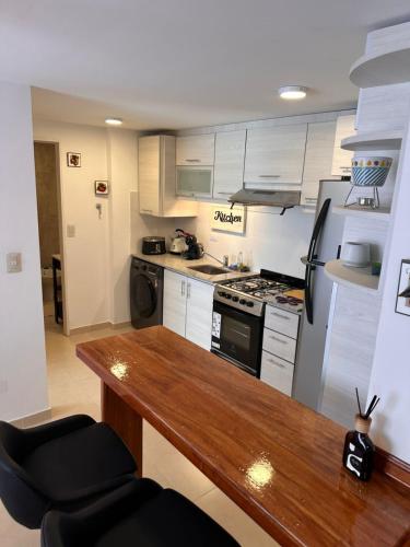 a kitchen with a wooden table and a stove at Hermoso departamento, excelente ubicación in El Palomar
