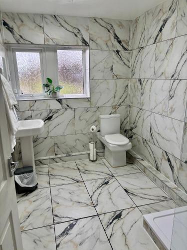 a white bathroom with a toilet and a sink at The Old Stone Trough Country Hotel in Kelbrook