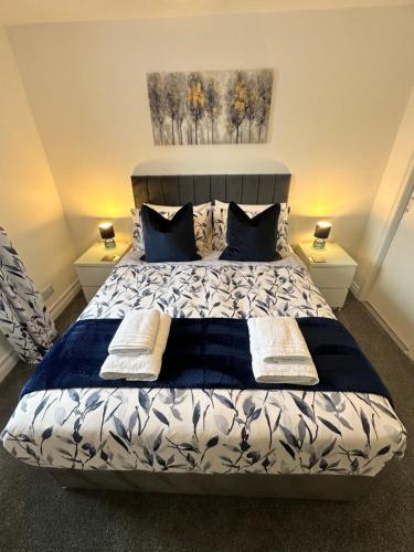 a bedroom with a bed with blue and white sheets and pillows at Kilmartin Court Apartments - No3 By The Sea & No2 With A View - free parking in Oban