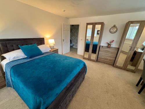 a bedroom with a bed with a blue blanket at The Old Stone Trough Country Hotel in Kelbrook
