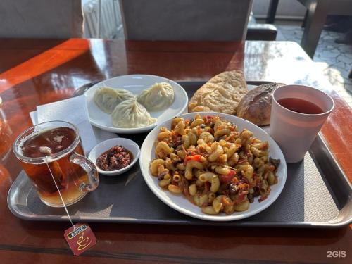 a tray with a plate of food on a table at Apple Hostel Bishkek in Bishkek