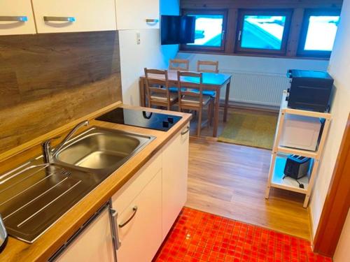 - une cuisine avec un évier et une table dans l'établissement Haus Dora Apartment 4 Panoramablick, à Mayrhofen