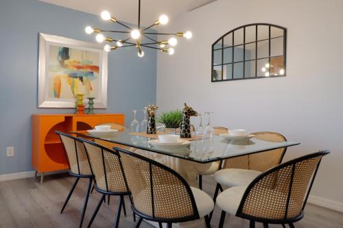 a dining room with a glass table and chairs at Making Dreams 4BR Family Villa with Pool and Game Room Near Disney Parks in Kissimmee