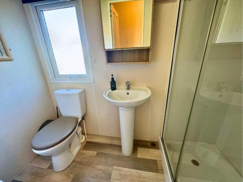 a bathroom with a toilet and a sink and a shower at Lovely Hot Tub Caravan in Northumberland, Free Golf Access, Dog Friendly in Swarland