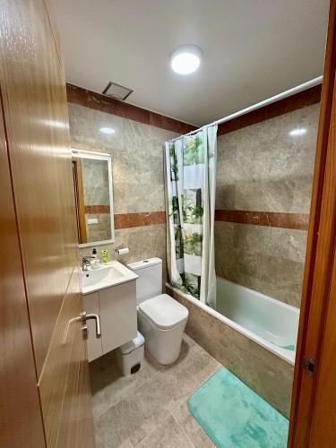 a bathroom with a toilet and a sink and a tub at VILLA CHRIS Ocean View in La Jaca