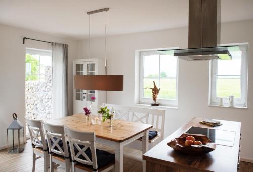 a kitchen and dining room with a wooden table and chairs at Bauernhof Höper-Rauert - Nr 9 Wellnesshaushälfte in Neujellingsdorf