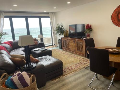 a living room with a couch and a television and a table at Casa Dourada - Golden Beach Apt in Budens