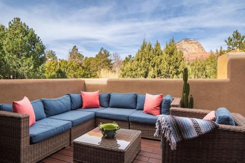 un patio avec un canapé bleu et des chaises en osier dans l'établissement Bella Vista Retreat, à Sedona