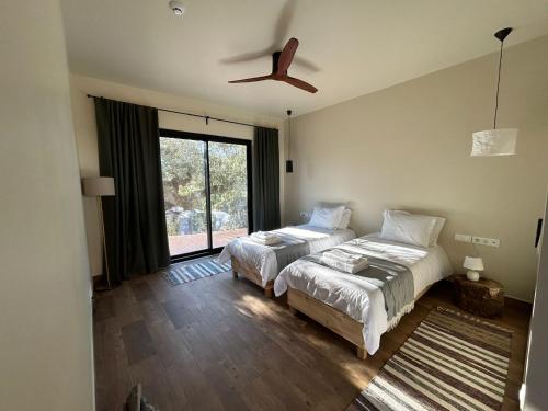 a bedroom with two beds and a ceiling fan at Monte do Roque in Évora Monte
