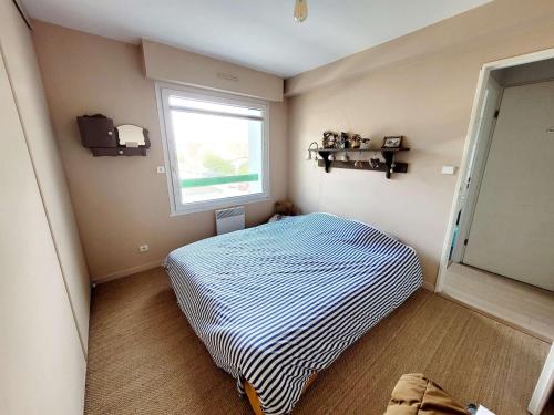 une petite chambre avec un lit et une fenêtre dans l'établissement Appartement 2 chambres avec balcon, à 100m de la plage - FR-1-675-14, à Wimereux