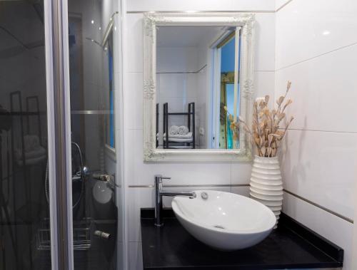 łazienka z białą umywalką i lustrem w obiekcie La Marina Suite Málaga w Maladze
