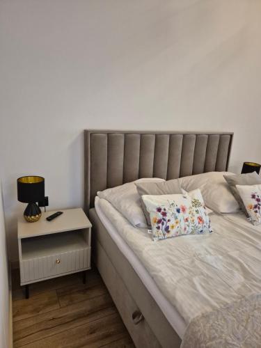 a bedroom with a bed with a side table with a lamp at Apartament z prywatna wanną hydromasaż - U Parów in Białka Tatrzanska