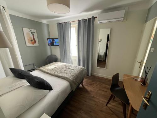a bedroom with a bed and a desk and a mirror at Le Clos d'Orange - Hotel & ville de Provence in Orange