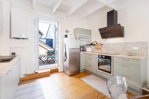 une cuisine blanche avec un réfrigérateur et une fenêtre dans l'établissement maison de ville Hyper centre, à La Turballe