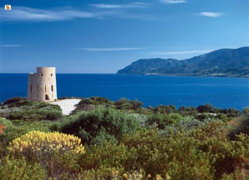 een vuurtoren aan de oever van een waterlichaam bij Virgilio's House in Tertenìa