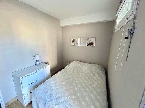 une chambre avec un lit, une commode et une fenêtre dans l'établissement Studio climatisé en bord de mer avec terrasse et parking privé - FR-1-716-43, à La Grande Motte