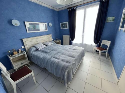 - une chambre bleue avec un lit et une chaise dans l'établissement Villa Indépendante à 50m de la Mer avec Jardin Clos et WIFI Gratuit, Idéal pour 8 Personnes - FR-1-324-551, à Saint-Gilles-Croix-de-Vie