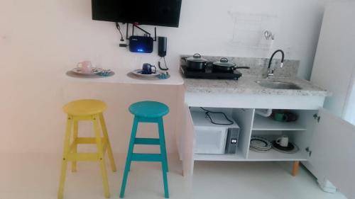 a kitchen with two stools and a counter with a sink at 805 Vista Mar Aconchegante in Salvador