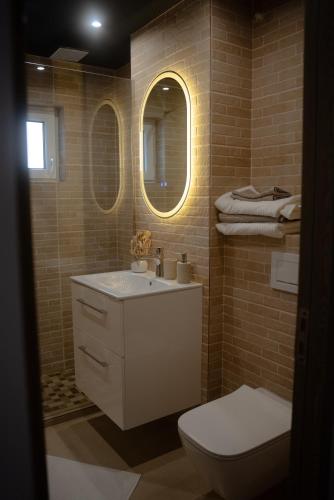a bathroom with a sink and a toilet and two mirrors at Ale Apartament aproape de facultate de medicina Vasile Goldis in Arad