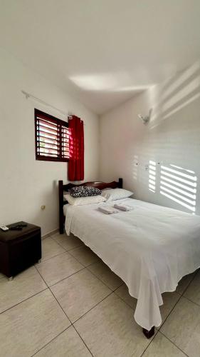a bedroom with a large bed and a window at Suíte House Pipa in Pipa