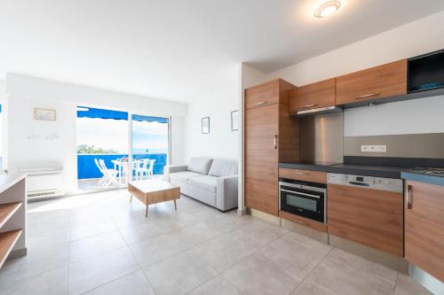 une cuisine et un salon avec un canapé et une table dans l'établissement 2-Br Seafront Apartment in Cannes, à Cannes