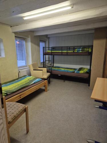 Zimmer mit 2 Etagenbetten und einem Stuhl in der Unterkunft Montage Wohnung zum Walnussbaum Deutschhof in Deutschhof
