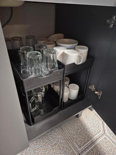 ein Regal mit Gläsern und Tassen auf einem Zimmer in der Unterkunft Montage Wohnung zum Walnussbaum Deutschhof in Deutschhof