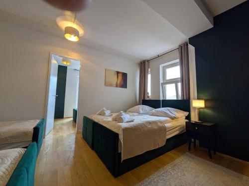 Munich Large Apartment 110 qm, 3 Bedrooms and very Central 1-12 Guests في ميونخ: غرفة نوم بها سريرين ونافذة