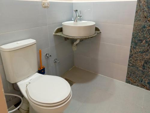 a bathroom with a white toilet and a sink at Bonita Chillhouse in Aswan