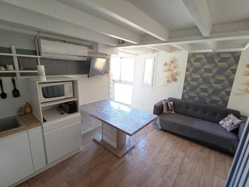 a living room with a couch and a table at T3 Duplex, centre port, clim, garage, piscine in Cap d'Agde