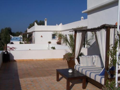 a patio with a couch and a table and a building at Villa Daba in Ghazoua