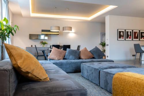 a living room with blue couches and a dining room at San Carlo Premium - Torino Centro in Turin