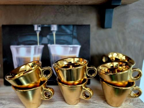 a group of gold coffee cups sitting on a table at Dream Boutique Edam Bed & Coffee in Edam