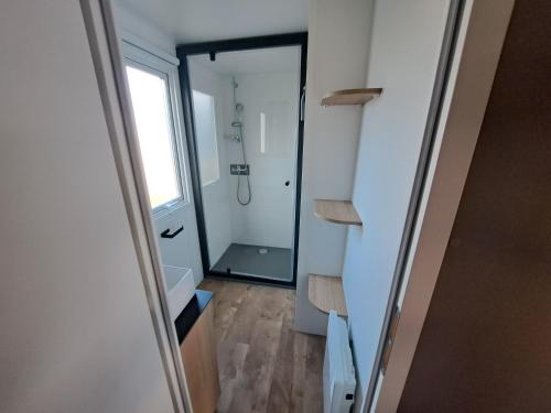 ein Bad mit einer Dusche und einem begehbaren Kleiderschrank in der Unterkunft Houlgate Mobilhome,3ch, 6pl, camp 5 étoiles, piscines, club enfants in Houlgate