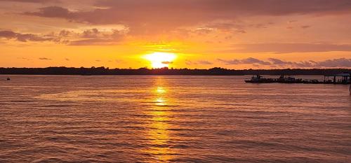 a sunset over a body of water with a pier at Edificio Regata INN in Buenaventura